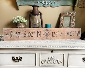 A personalized location sign with a compass in the center. The sign is 36 x 5.25 inches. The lettering is wood-burned onto reclaimed wood. 